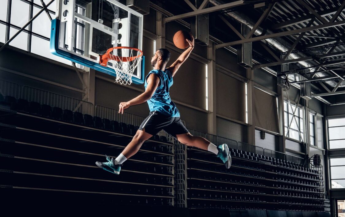 A man jump and throw a basketball