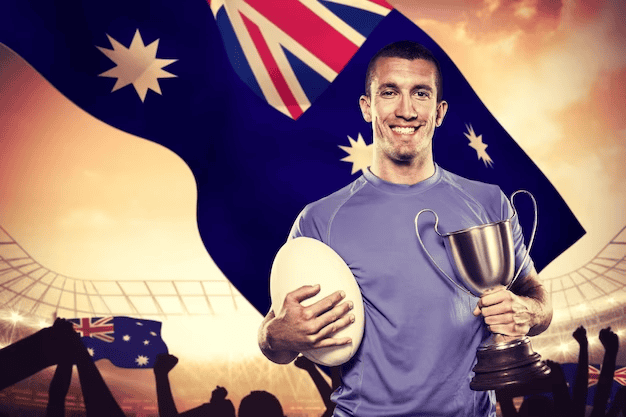 Smiling rugby player holding trophy and ball