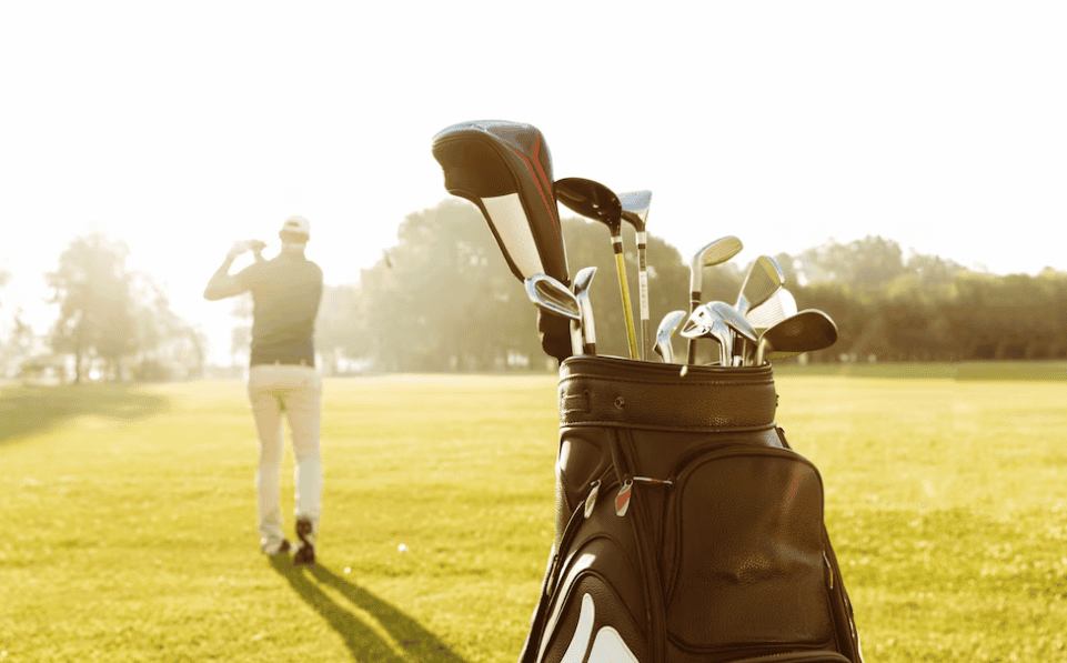man playing golf, a bag with golf tools