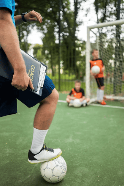 Football trainer teaching his pupils