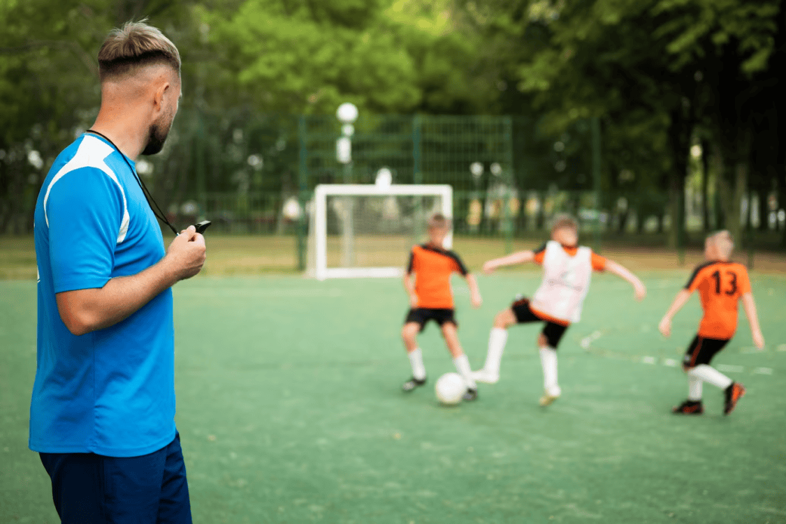 Football coach watching his students play