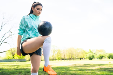 Girl holding a soccer ball on her knee