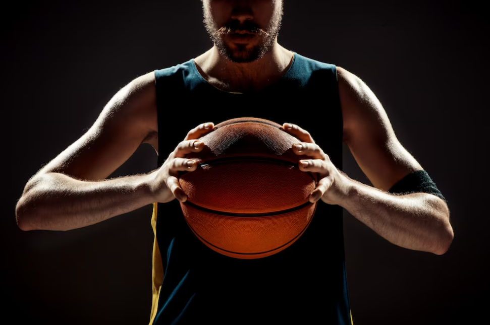 silhouette of a basketball player holding basketball ball on black background