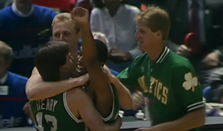 Larry Bird embracing teammates on the basketball court