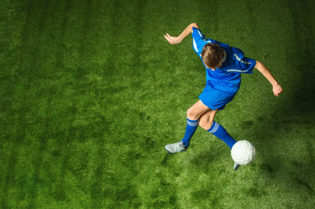 soccer players in blue sport suit kicking the ball on football field