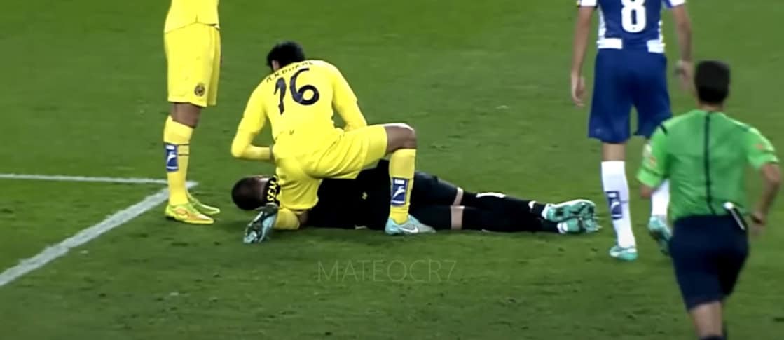 A football player helps another player who is lying on the field