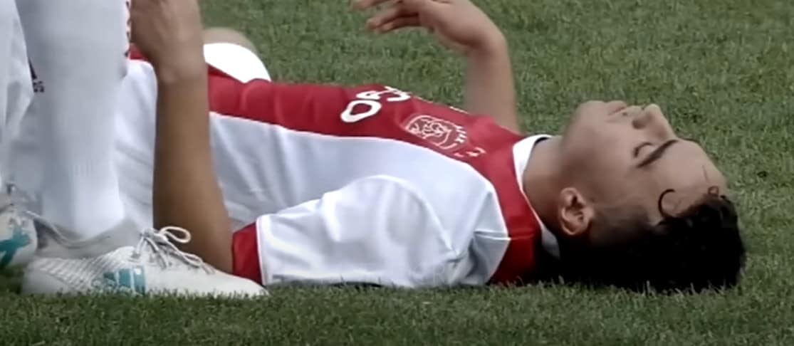 An unconscious football player lies on the field