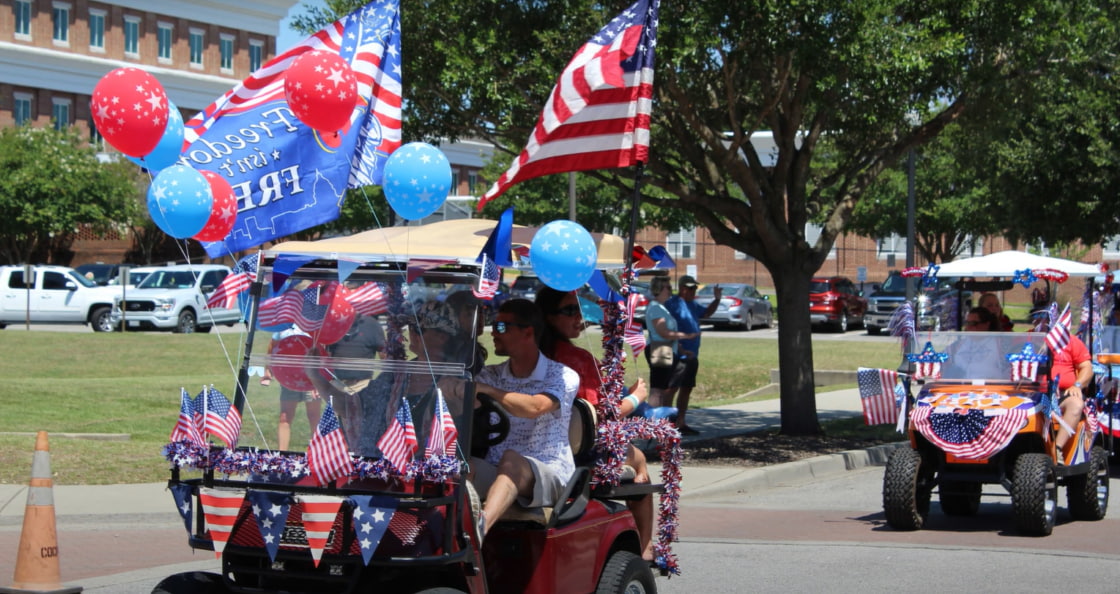 Golf cart decorated with balloons and American flags