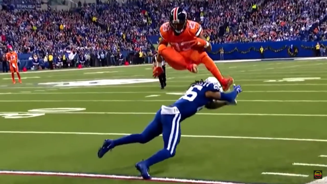 gameplay - player in orange suit jumping over player in blue suit on the field